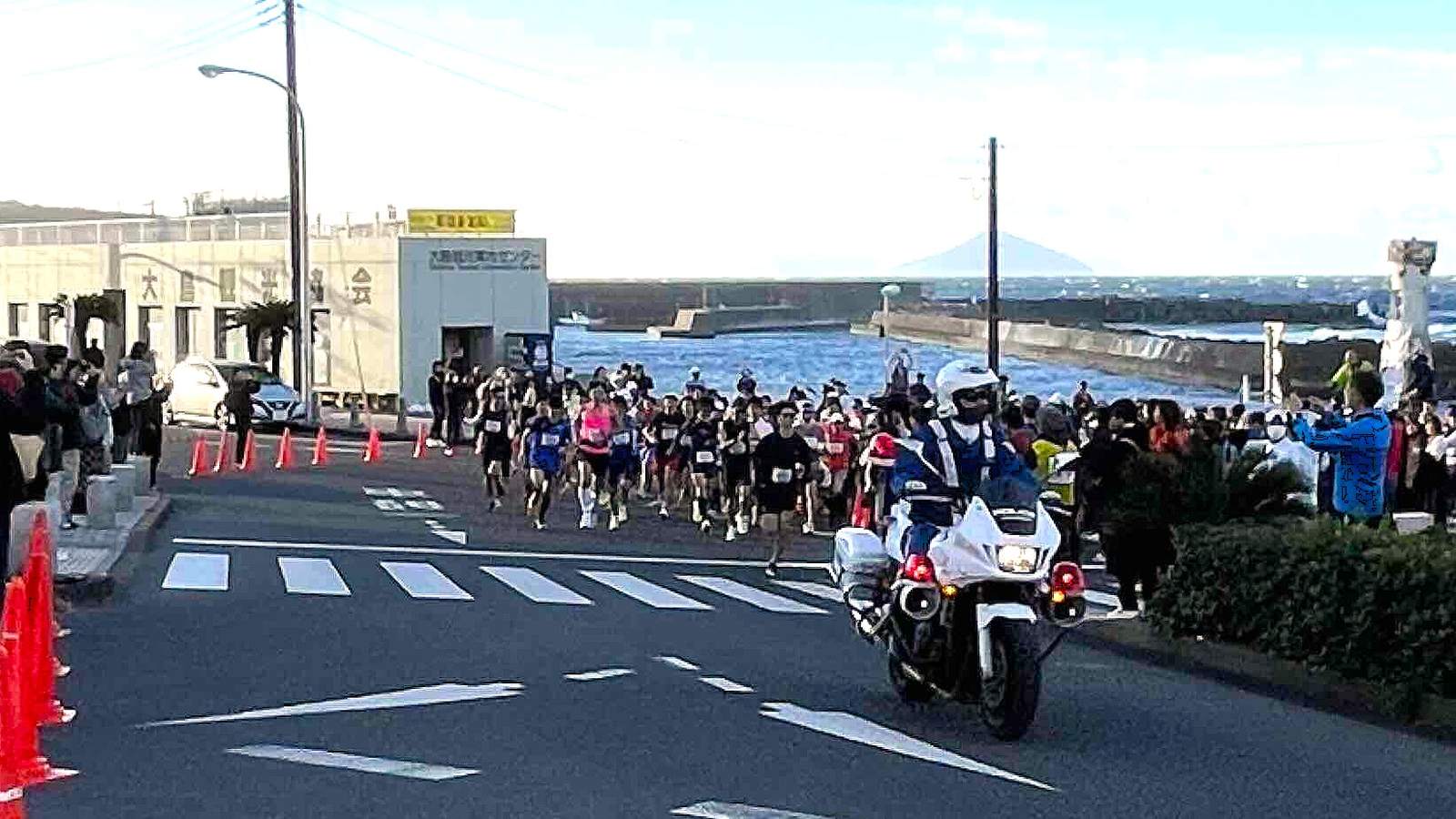 伊豆大島マラソンのスタート。海沿いの道を白バイが先導する